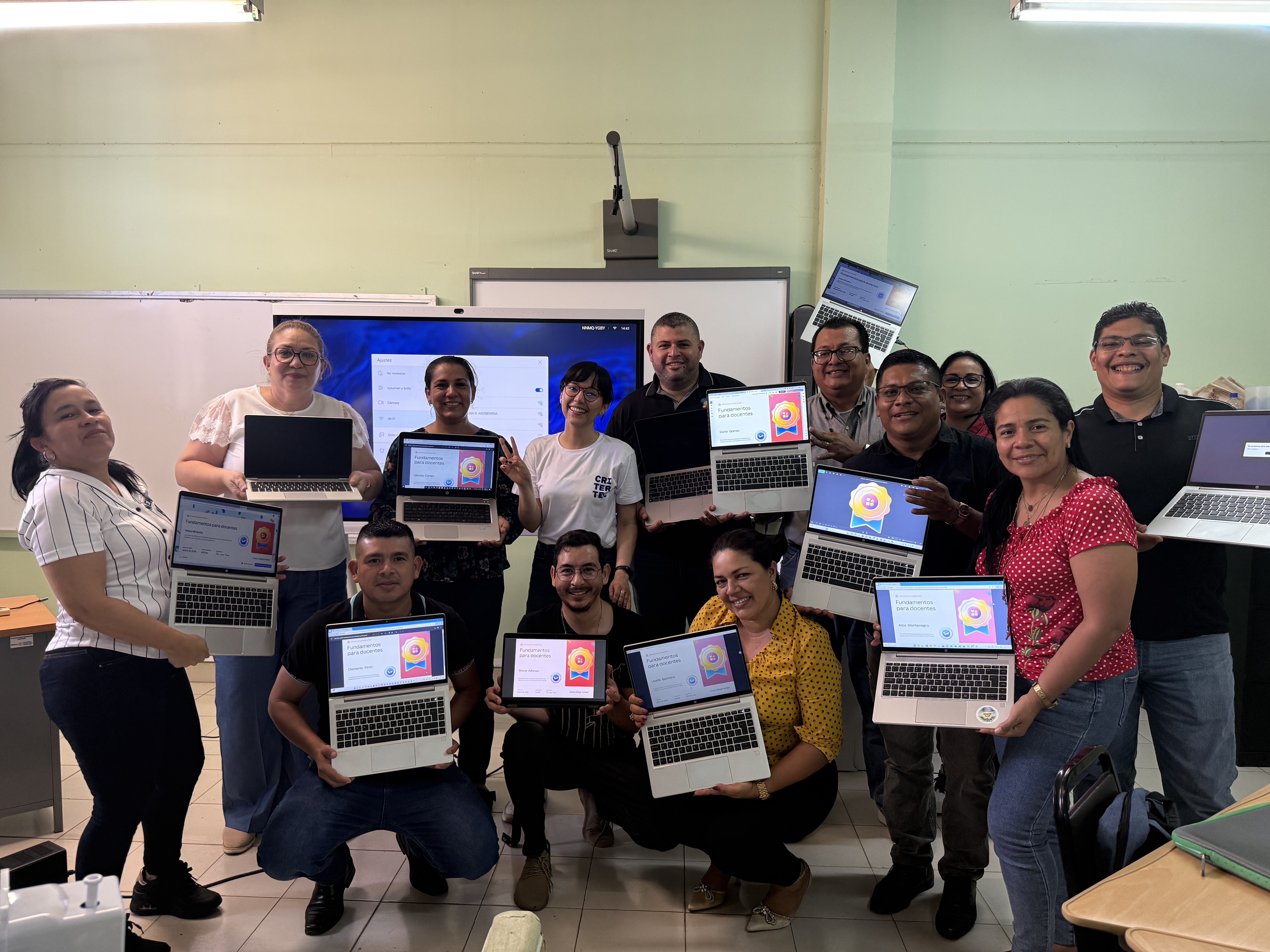Cohorte de facilitadores con equipo Critertec sosteniendo laptops con certificación Fundamentos para docentes · MEDUCA Panamá